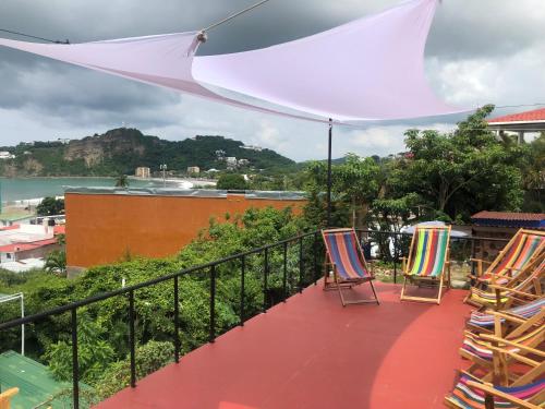 a balcony with chairs and a view of the ocean at Hostel SaltWater in San Juan del Sur
