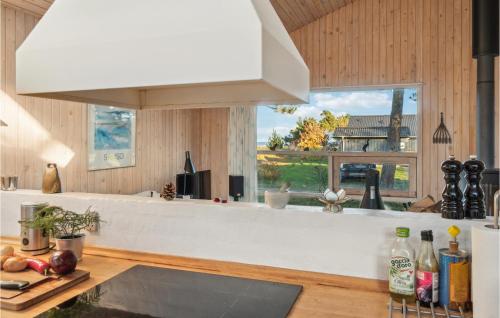 a kitchen with a white counter top and a window at Beautiful Home In Sams With Kitchen in Nordby