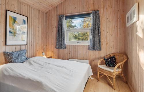 a bedroom with a bed and a window and a chair at Beautiful Home In Sams With Kitchen in Nordby