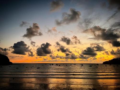 a sunset over the ocean with a group of birds at Hostel SaltWater in San Juan del Sur