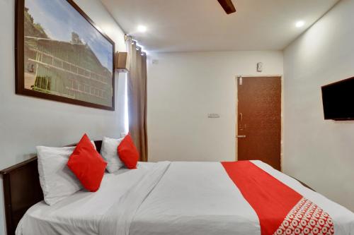 a bedroom with a large bed with red pillows at OYO Flagship Hotel Shiva Shakthi Inn in Bangalore