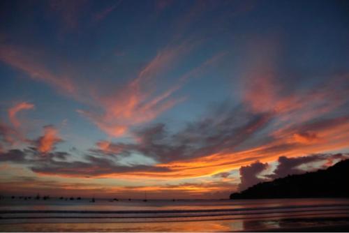 a sunset on the beach with a cloudy sky at Hostel SaltWater in San Juan del Sur