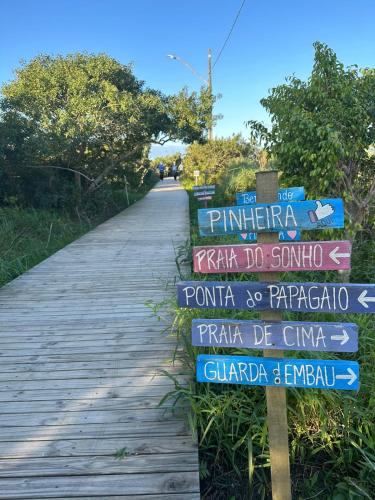 a bunch of signs on a wooden path at Villa Cavaliere in Palhoça