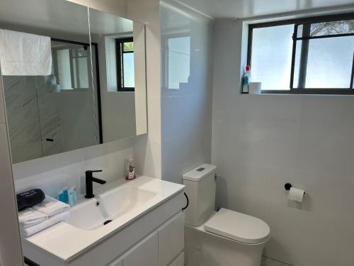 黃金海岸的住宿－Kirra Beach Unit，白色的浴室设有水槽和卫生间。