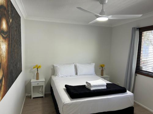 黃金海岸的住宿－Kirra Beach Unit，卧室配有白色的床和吊扇