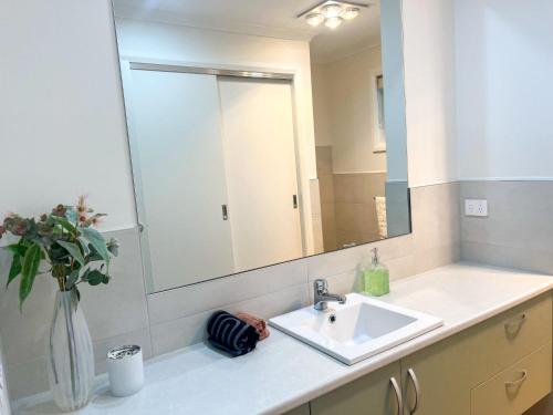 Un baño con lavabo y un espejo grande. en Eucalyptus House, en Timboon