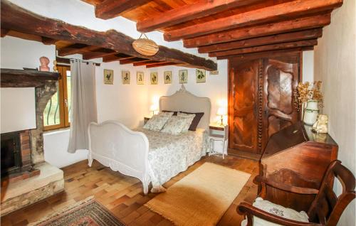 ein Schlafzimmer mit einem weißen Bett und einem Kamin in der Unterkunft 3 Bedroom Gorgeous Home In Salles Sous Bois in Salles-sous-Bois