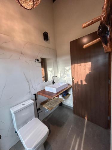 a bathroom with a white toilet and a sink at Chalé Pousada Maná do Céu - São Jorge in Sao Jorge
