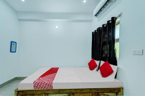 a bedroom with a bed with red pillows at OYO Flagship Your Room & Guest House in Patna