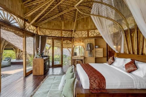 um quarto com uma cama grande numa tenda em Arapan Ubud Eco Villa em Ubud