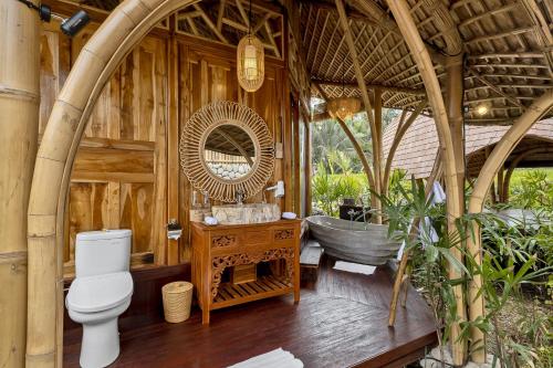 a bathroom with a toilet and a bath tub at Arapan Ubud Eco Villa in Ubud