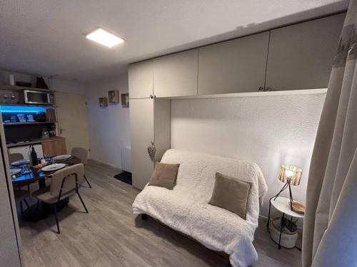 une chambre avec un lit, un bureau et une table dans l'établissement Studio cabine rénové 4 pers avec jardinet et accès parking – cœur de station - FR-1-592-64, à Font-Romeu