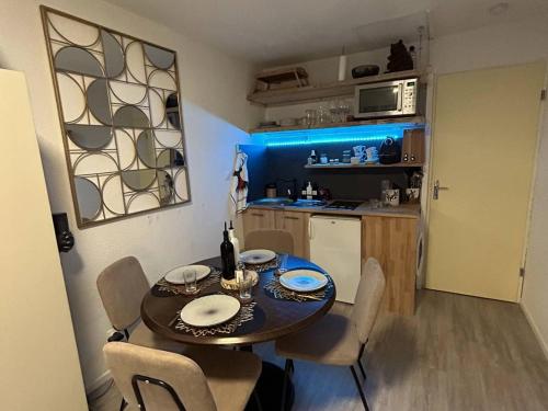 a small kitchen with a table and chairs in a room at Studio Bolquère-Pyrénées 2000, 1 pièce, 4 personnes - FR-1-592-64 in Font-Romeu