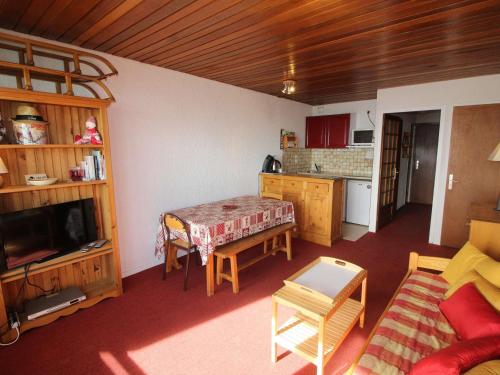 un salon avec une table et une cuisine dans l'établissement Duplex 3 pièces cabine 8 pers, pied des pistes à Auris en Oisans - FR-1-297-337, à Auris