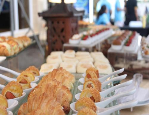 a bunch of pastries on plates on a table at Grand Mercure Solo Baru in Solo