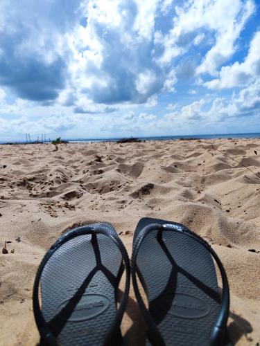 a pair of shoes sitting in the sand on a beach at Pousada Pôr do Sol in Barra Grande
