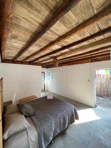 a bedroom with a bed and a wooden ceiling at Macarena Paredon in El Paredón Buena Vista