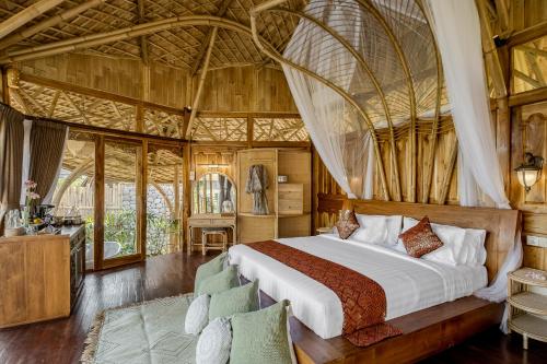 a bedroom with a bed in a large room at Arapan Ubud Eco Villa in Ubud