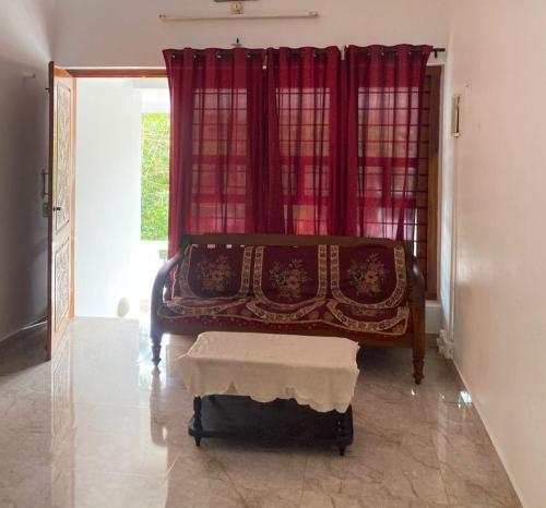 Un dormitorio con una cama con una cortina roja. en Chills homestay, en Kalpetta