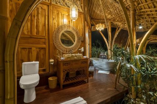 a bathroom with a toilet and a sink and a tub at Arapan Ubud Eco Villa in Ubud