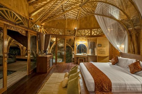 a bedroom with a large bed in a room with at Arapan Ubud Eco Villa in Ubud