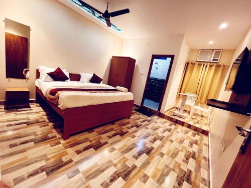 1 dormitorio con 1 cama y suelo de madera en RR PALACE en Gorakhpur