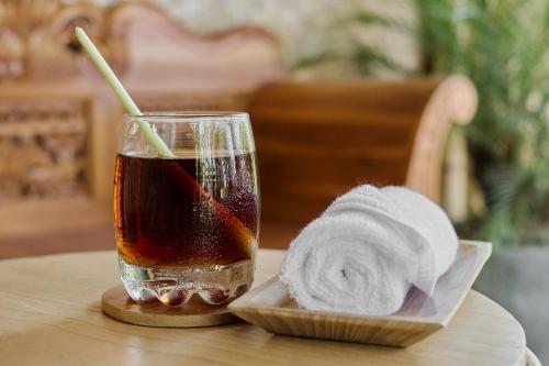 a drink and a towel on a table next to a napkin at Arapan Ubud Eco Villa in Ubud