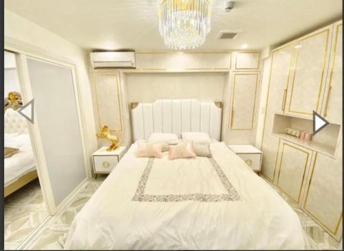 a bedroom with a large white bed with pink pillows at Reimi Mondo201 in Tokyo