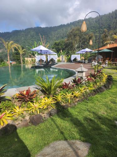 a pool at a resort with tables and umbrellas at Starlake Villa & Glamping in Kubupenlokan