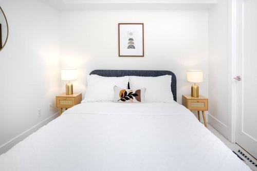 a white bedroom with a white bed with two lamps at Chic 1-BR Condo; Parking included; Downtown Core in Toronto