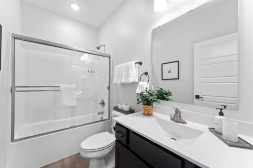 a white bathroom with a toilet and a sink at Serenity Point Lodge in Branson