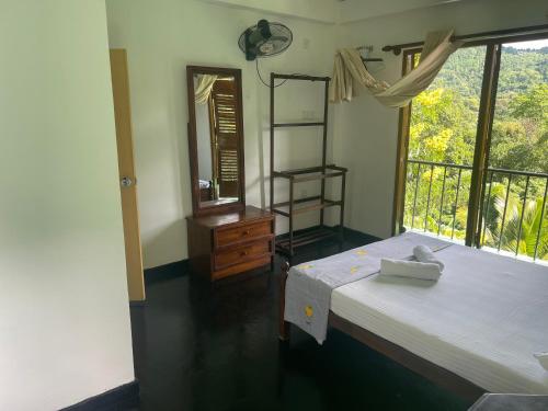 a bedroom with a bed and a dresser and a window at Eagles Eco Lodge - Kandy in Digana