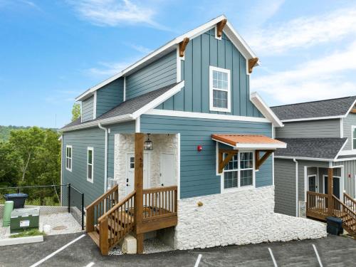 a blue house with a porch and a deck at Serenity Point Lodge in Branson