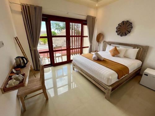 a bedroom with a bed and a large window at The Pulau Bungalow in Nusa Lembongan