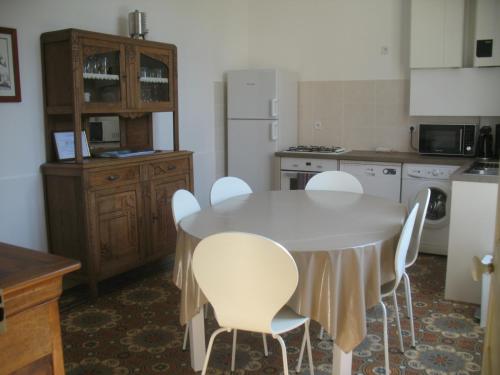 a kitchen with a white table and white chairs at Gite le Vaudésir in Ligny-le-Châtel