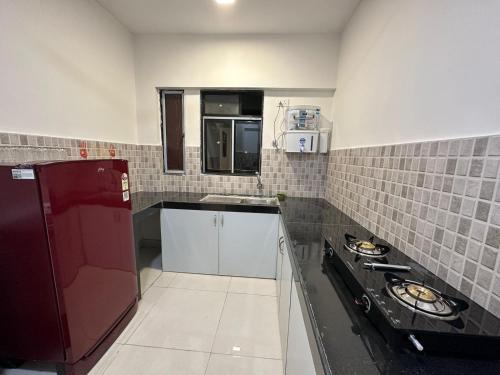 uma pequena cozinha com uma parede de azulejos vermelhos e brancos em 1bed room Mumbai theme Lower Parel em Mumbai