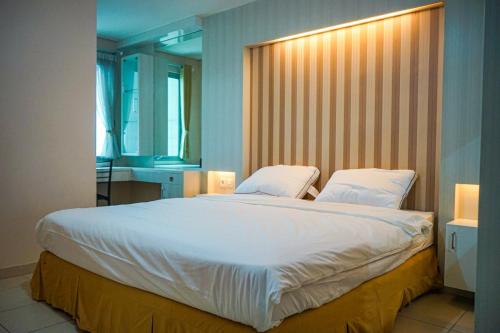 a large white bed in a room with a window at Apartemen Solo Center Point in Bonorejo