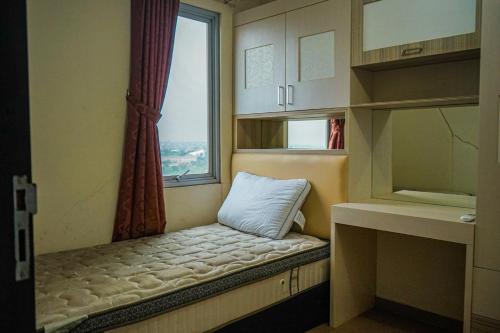 a small room with a window and a bench with a pillow at Apartemen Solo Center Point in Bonorejo