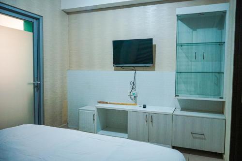 a bedroom with a bed and a sink and a tv at Apartemen Solo Center Point in Bonorejo