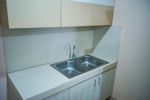 a small kitchen with a sink and white cabinets at Apartemen Solo Center Point in Bonorejo