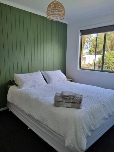 una camera da letto con un grande letto bianco e una finestra di Cottage for two, Marlo a Marlo