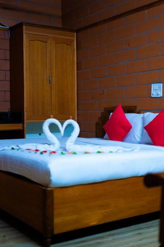 a bed with two white hearts on top of it at The Nest Inn Resort in Masinagudi