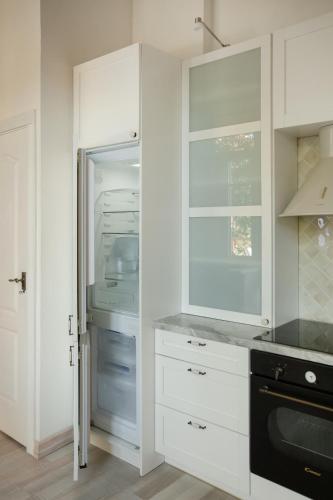 a kitchen with white cabinets and an open refrigerator at 20 stairs in Vilnius