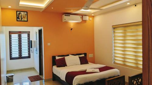 a bedroom with a bed with an orange wall at SILVERY MOON GRAND VILLA in Tariyod
