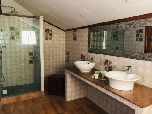 a bathroom with two sinks and a shower at Villa Des Flots in La Réunion