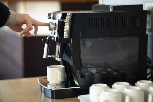a person is pouring coffee into a coffee machine at Yuzawa house in Yuzawa