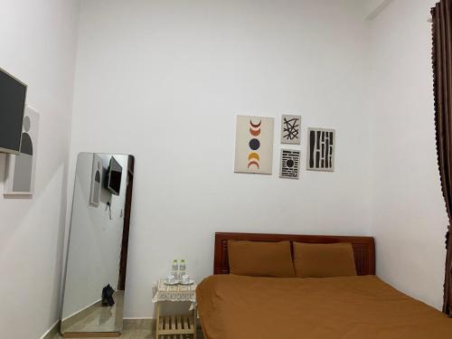 ein Schlafzimmer mit einem Bett und einige Bilder an der Wand in der Unterkunft The New House in Ấp Ða Lợi