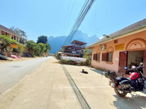 a motorcycle parked on the side of a street at phoulisack guesthouse in Ban Sôphoun
