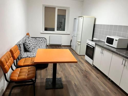 a kitchen with a couch and a table in a room at Квартира in Karagandy