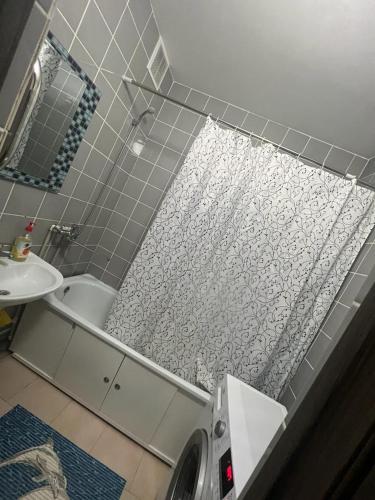 a bathroom with a shower and a toilet and a sink at Квартира in Karagandy